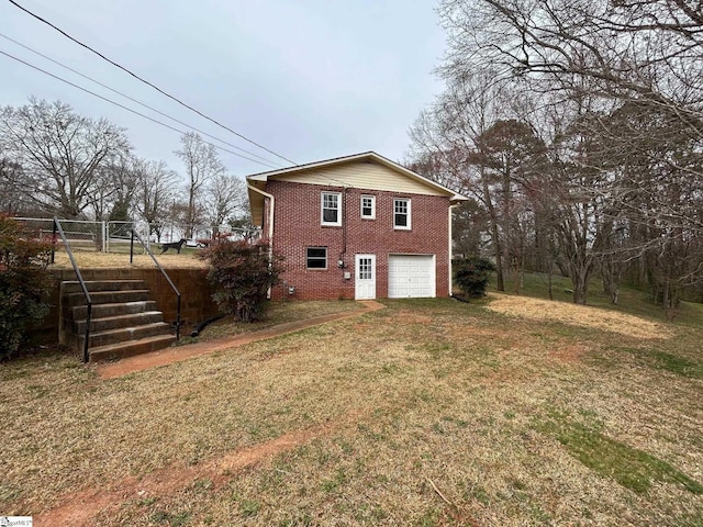 exterior space featuring an attached garage, a lawn, brick siding, and driveway