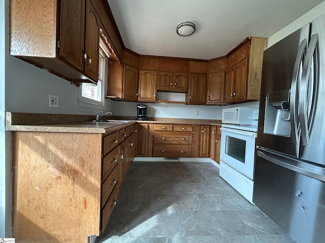 kitchen with oven, brown cabinets, stainless steel refrigerator with ice dispenser, marble finish floor, and a sink