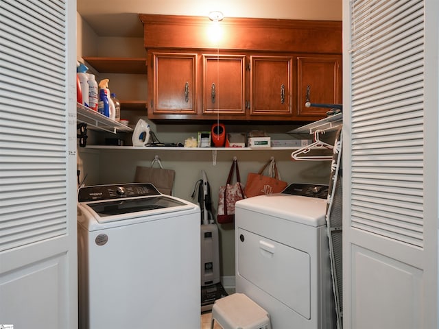 clothes washing area featuring cabinet space and independent washer and dryer