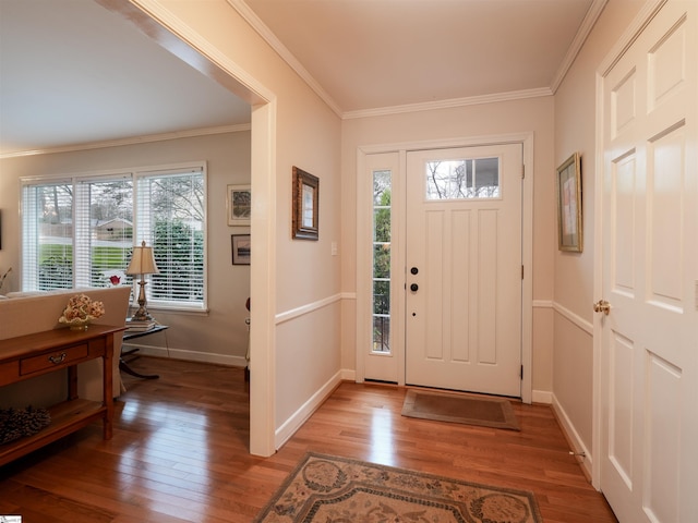 foyer entrance featuring light wood-style flooring, crown molding, and baseboards