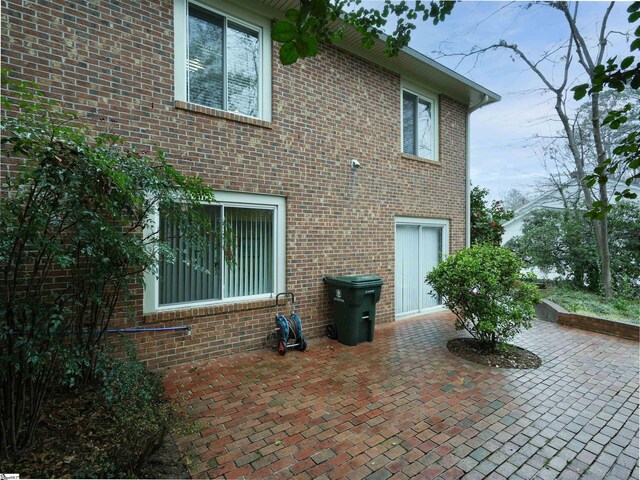 exterior space featuring brick siding and a patio area