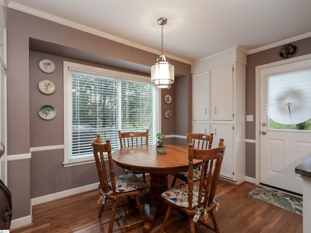 dining room featuring baseboards, wood finished floors, and ornamental molding