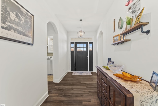 foyer with arched walkways, separate washer and dryer, baseboards, and dark wood-style flooring