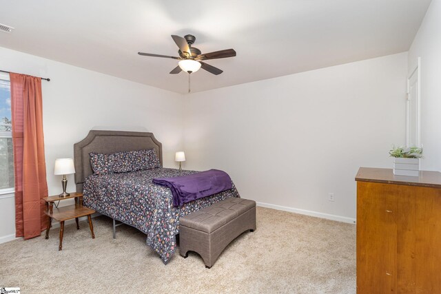 carpeted bedroom with visible vents, a ceiling fan, and baseboards