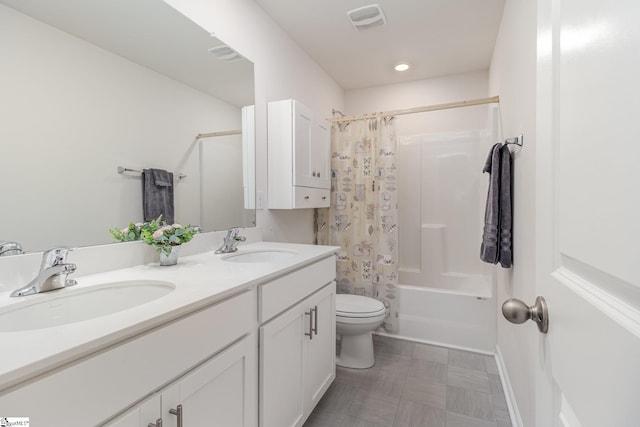 bathroom featuring a sink, visible vents, toilet, and double vanity