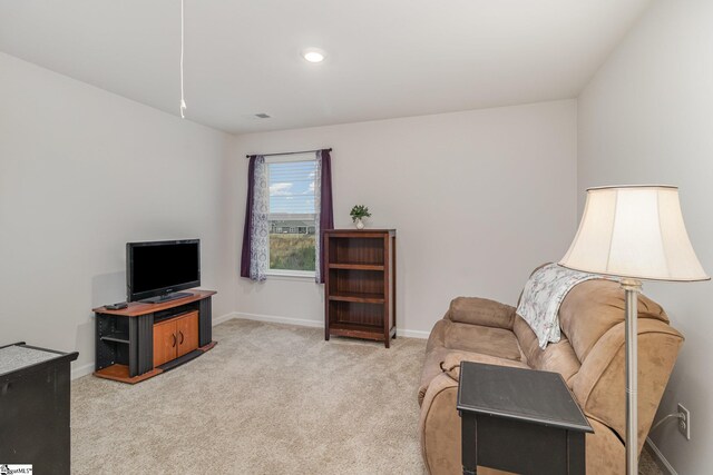 living area featuring visible vents, baseboards, and carpet