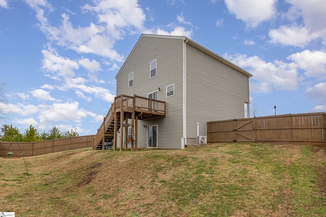 rear view of property featuring stairs, fence, a deck, and a gate