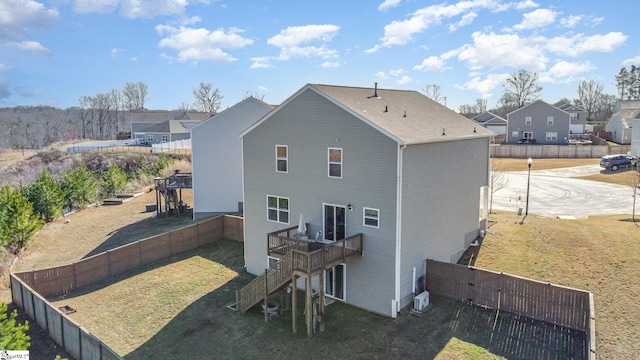 back of house featuring stairway, a fenced backyard, a lawn, and a wooden deck