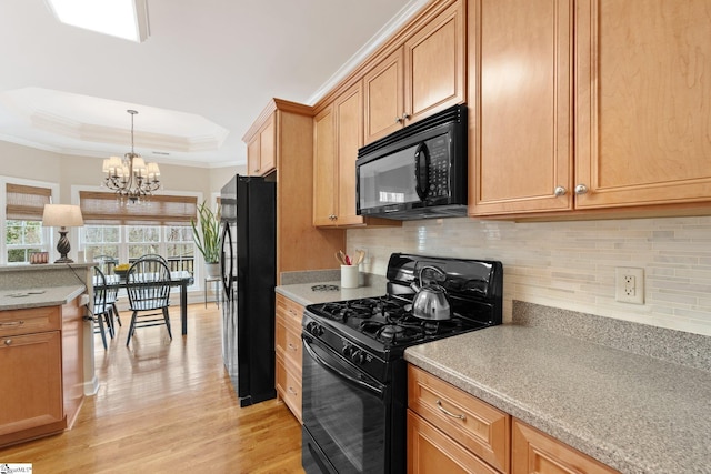 kitchen with decorative backsplash, black appliances, crown molding, light wood-type flooring, and a raised ceiling