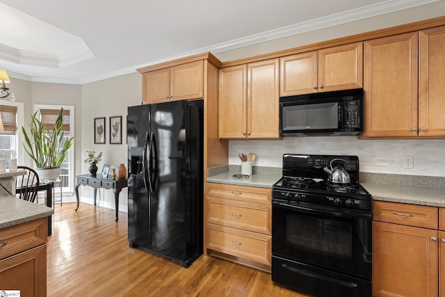 kitchen with decorative backsplash, light wood-style flooring, black appliances, and ornamental molding