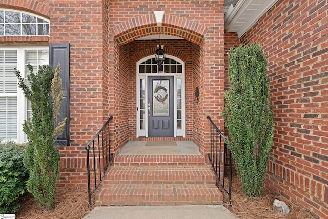 view of exterior entry featuring brick siding