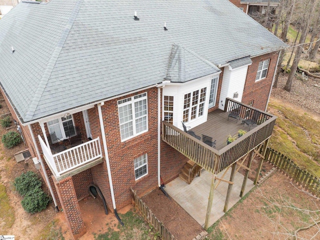 back of house with stairway, brick siding, and a shingled roof