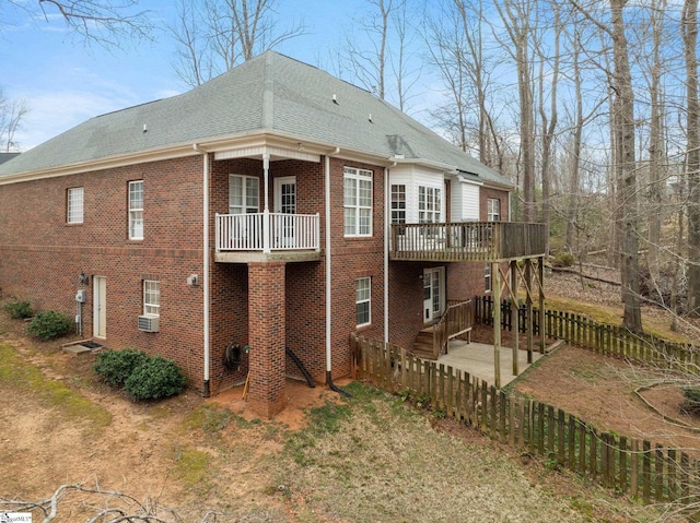 back of property featuring fence private yard, brick siding, and a shingled roof