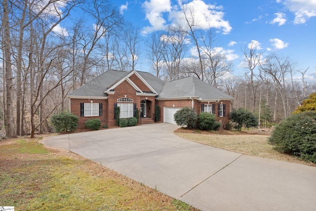 view of front of home featuring a front yard, roof with shingles, concrete driveway, a garage, and brick siding