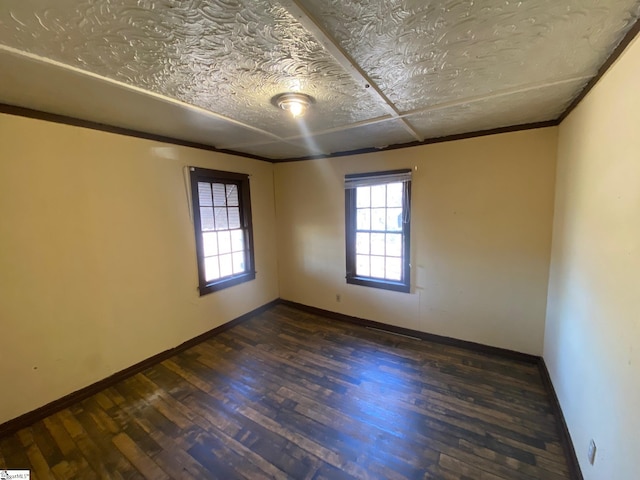 empty room featuring baseboards and wood finished floors