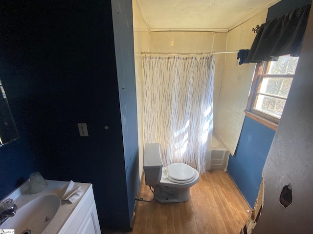 bathroom featuring shower / bathtub combination with curtain, toilet, wood finished floors, and vanity