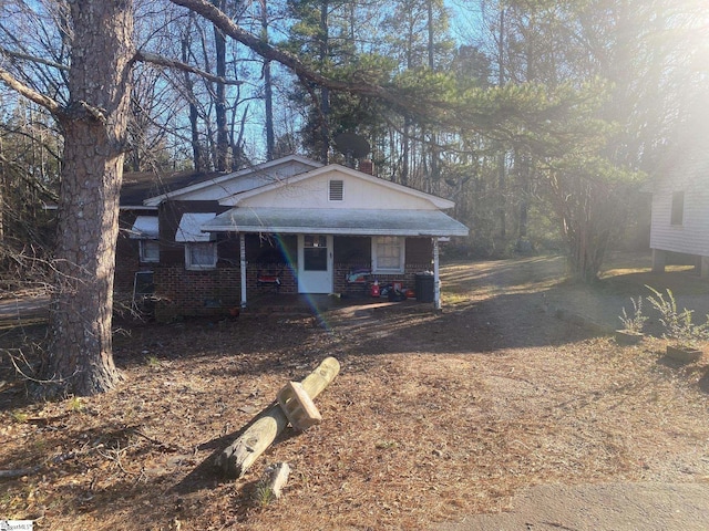 bungalow featuring brick siding