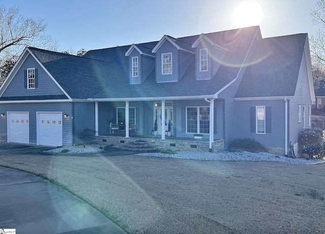 cape cod house featuring a garage, driveway, a porch, a shingled roof, and crawl space