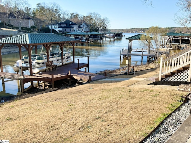 view of dock with boat lift, a yard, and a water view