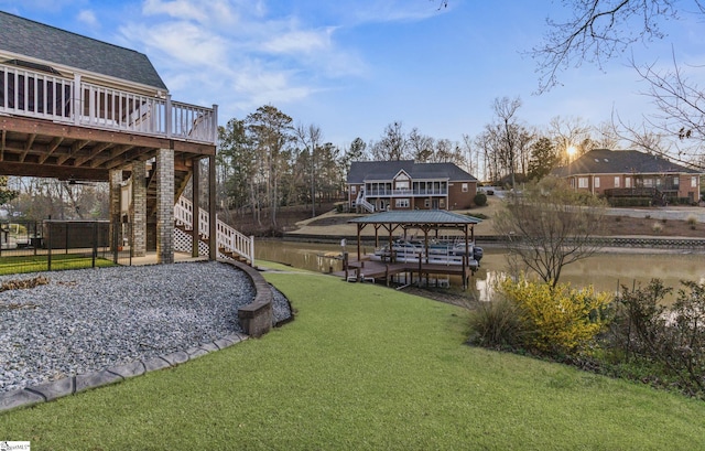 view of yard featuring a deck, a boat dock, and stairs