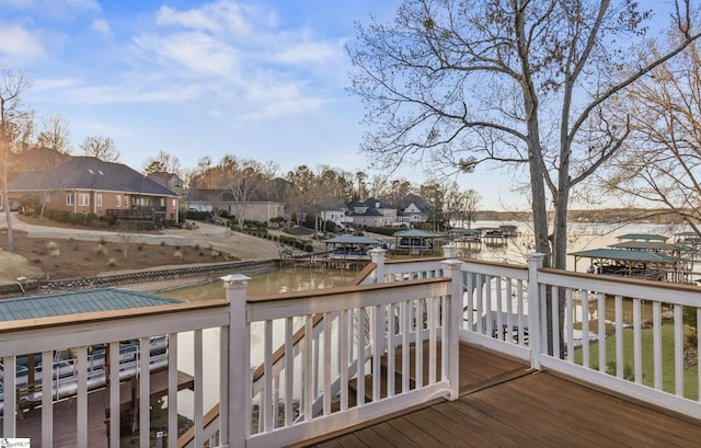 wooden deck with a residential view and a water view