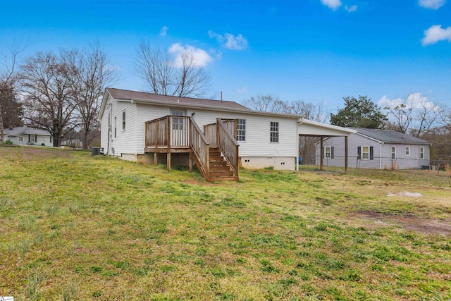 back of property with an attached carport, a wooden deck, stairs, a yard, and crawl space