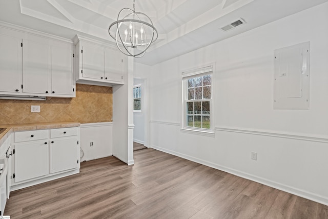 kitchen featuring electric panel, visible vents, white cabinets, and light wood finished floors