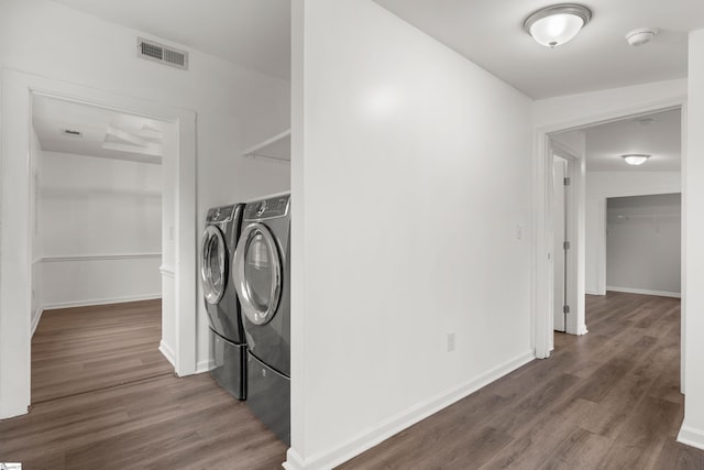 washroom with visible vents, washer and clothes dryer, dark wood finished floors, baseboards, and laundry area