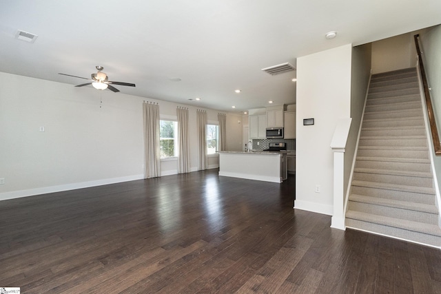 100 Outback Dr, Greer, SC 29650 - unfurnished living room featuring dark wood-style floors, visible vents, stairs, and baseboards