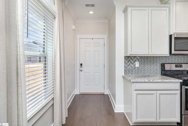 kitchen featuring tasteful backsplash, visible vents, baseboards, dark wood finished floors, and stainless steel appliances