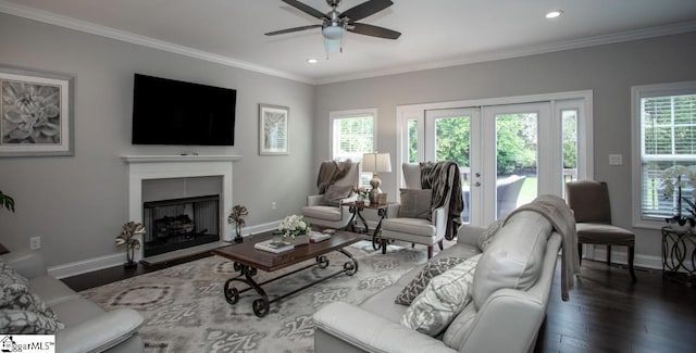 living area featuring baseboards, wood finished floors, and crown molding