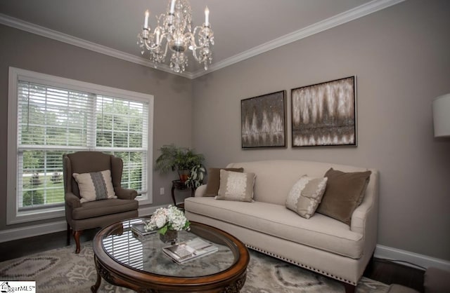 living area with an inviting chandelier, wood finished floors, baseboards, and ornamental molding