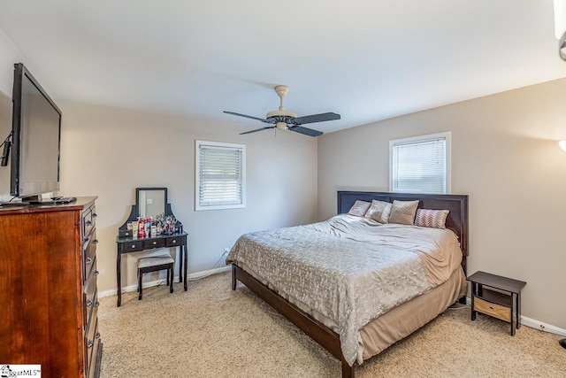 bedroom with a ceiling fan, baseboards, and light carpet