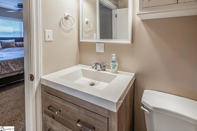 ensuite bathroom featuring toilet, vanity, ensuite bathroom, and ceiling fan