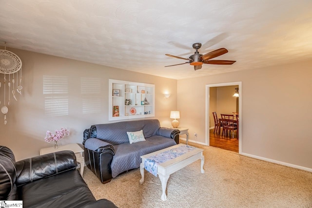 living room featuring ceiling fan, carpet, and baseboards