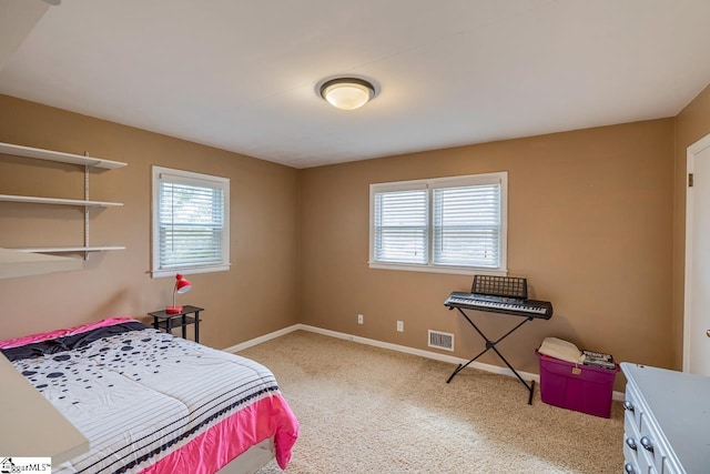 carpeted bedroom featuring visible vents, multiple windows, and baseboards