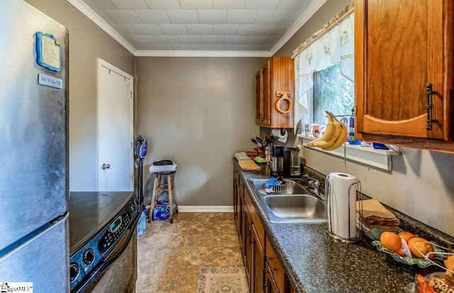 kitchen with crown molding, brown cabinets, freestanding refrigerator, and a sink