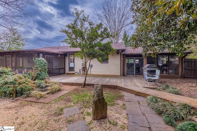 back of house featuring a wooden deck and a sunroom