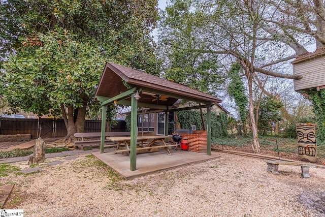 exterior space featuring a gazebo, ceiling fan, and fence