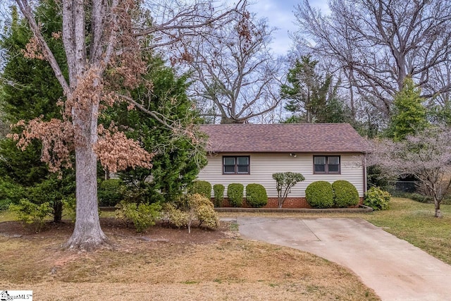 view of front of house featuring a front lawn and roof with shingles