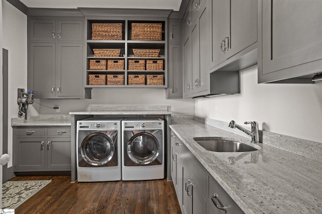 clothes washing area with a sink, cabinet space, dark wood-type flooring, and separate washer and dryer