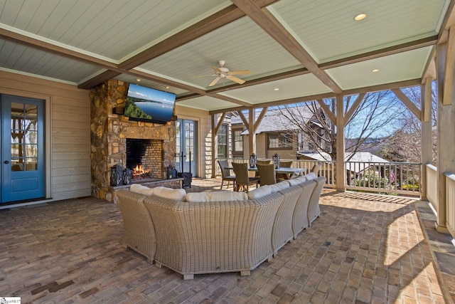 view of patio / terrace featuring outdoor dining space, an outdoor stone fireplace, and ceiling fan