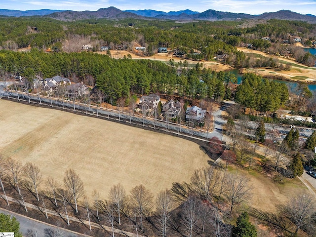 drone / aerial view with a forest view and a water and mountain view