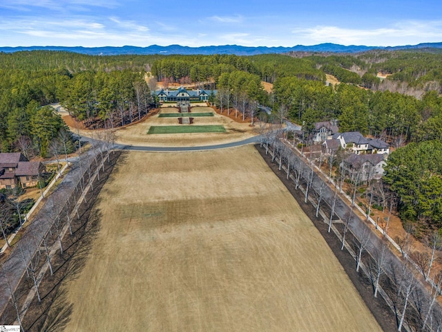 birds eye view of property featuring a mountain view and a wooded view