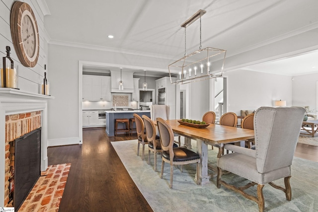 dining space with baseboards, a fireplace, dark wood-style flooring, and crown molding