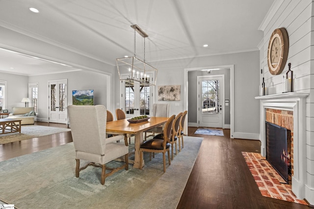 dining space featuring ornamental molding, dark wood-style floors, recessed lighting, baseboards, and a brick fireplace