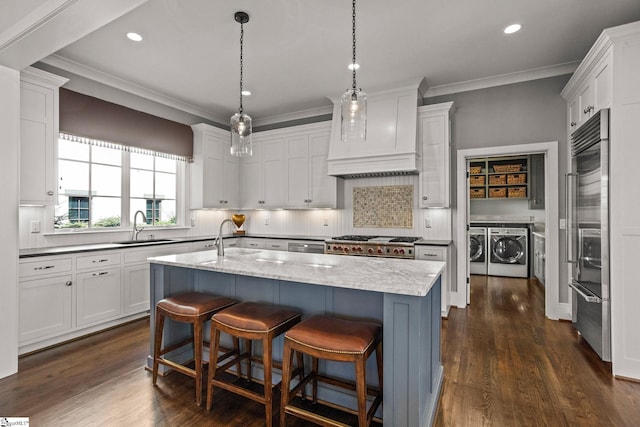 kitchen with ornamental molding, custom range hood, a sink, separate washer and dryer, and white cabinets