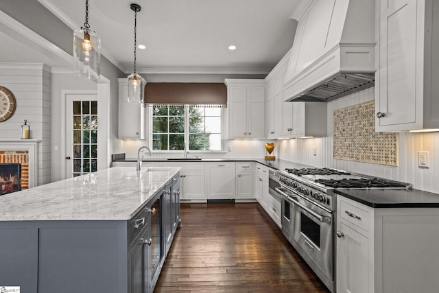 kitchen featuring dark wood finished floors, white cabinetry, custom range hood, and range with two ovens