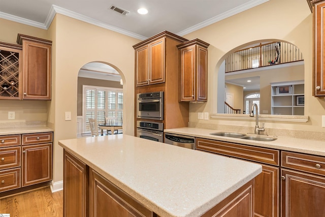 kitchen with visible vents, arched walkways, ornamental molding, stainless steel appliances, and a sink