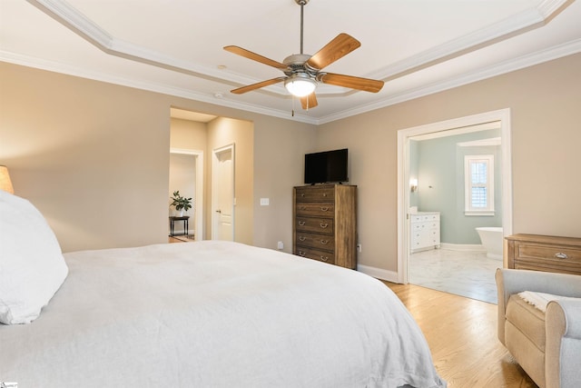 bedroom with connected bathroom, baseboards, wood finished floors, and ornamental molding